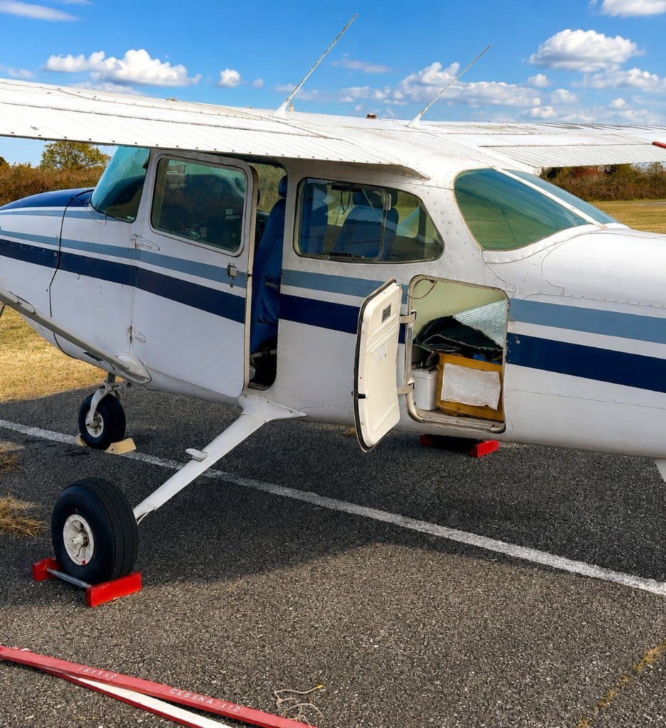 Cessna 172 single-engine aircraft on the ramp with cabin and baggage doors open